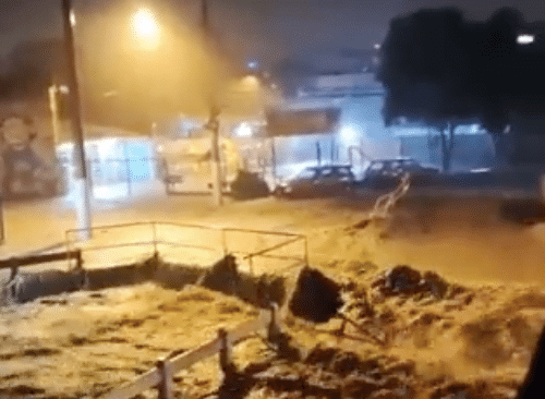 Correnteza formada pela chuva passa sobre a rua e a ponte. Rio e rua viram a mesma coisa.