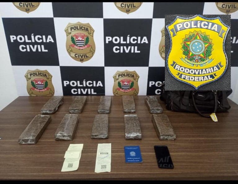 Foto mostra tijolos de maconha sobre a mesa, com documentos e bilhete de passagem do ônibus.
