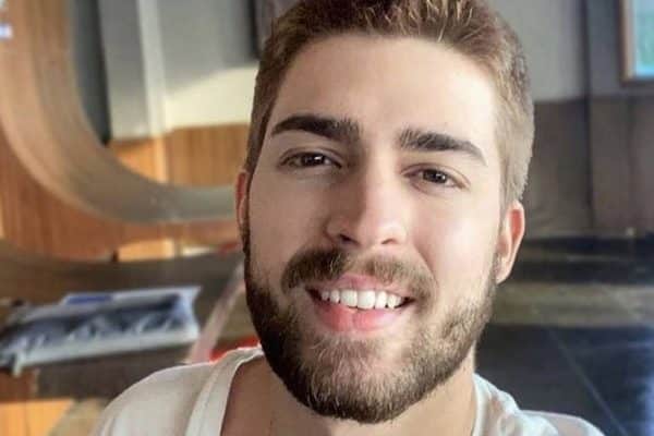 Rosto de Marcos Vitor Aguiar Dantas Pereira, homem de pele clara, com barba, cabelos claros, sorri para foto.