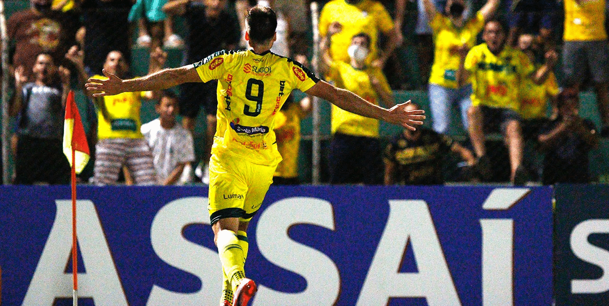 Jogador do mirassol comemora gol correndo na direção da torcida. Torcedores também comemoram diante da aproximação do jogador