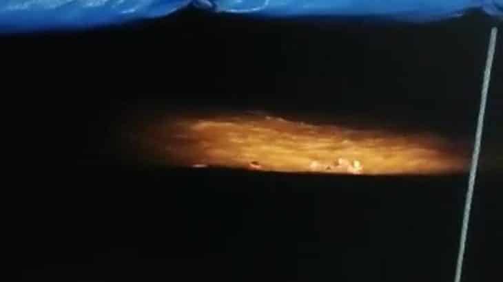 Imagem mostra pessoas caídas no rio durante a noite.