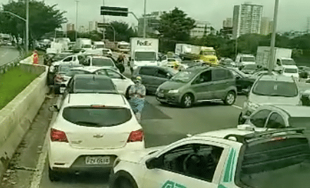 Marginal Tietê com trânsito bloqueada. Mostra carros na contra mão, pessoas andando no asfalto.