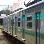 Trem da CPTM. Imagem mostra parte de um vagão, adesivado com uma tarja verde cortando ao meio e é possível ler "Via mobilidade" na lataria.