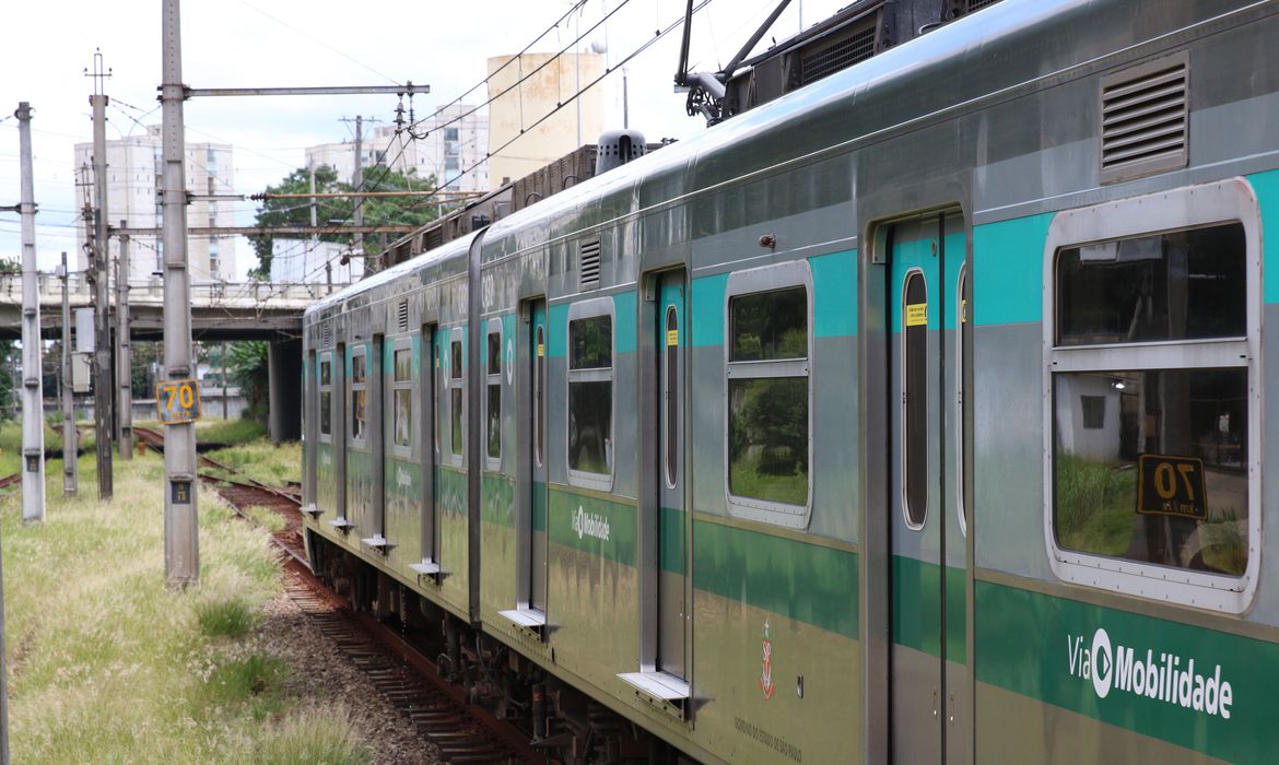 Trem da CPTM. Imagem mostra parte de um vagão, adesivado com uma tarja verde cortando ao meio e é possível ler "Via mobilidade" na lataria.