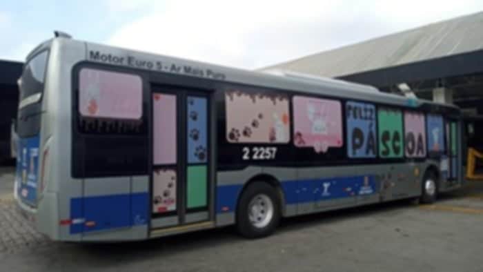 Ônibus parado com adesivos nos vidros em referência à pascoa e ao carnaval.