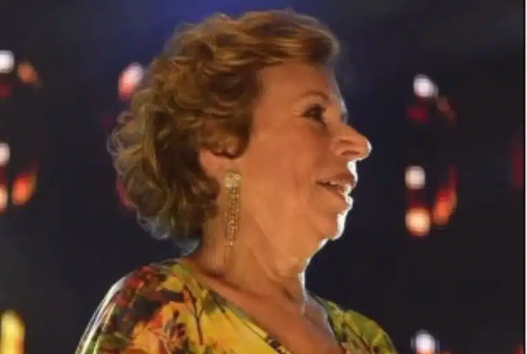 Foto de Marilene feita de baixo para cima mostra artista sorrindo, com brinco longo na orelha.
