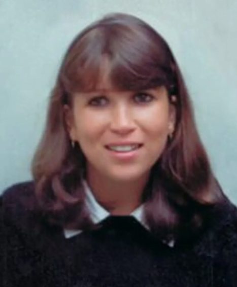 Isabel Cristina aparece em foto de cabelos longos, escuros, sorrindo discretamente. Sua pele é clara. O cabelo está penteado separado ao meio com uma franja caída sobre a testa.