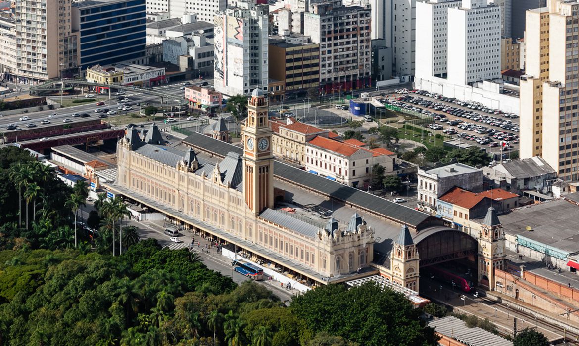 imagem aérea mostra prédio do Museu da Língua Portuguesa em meio a prédios e arvores na região central de são Paulo.