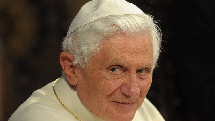 Papa Bento 16, senhor de pele clara, cabelos brancos penteados para trás.