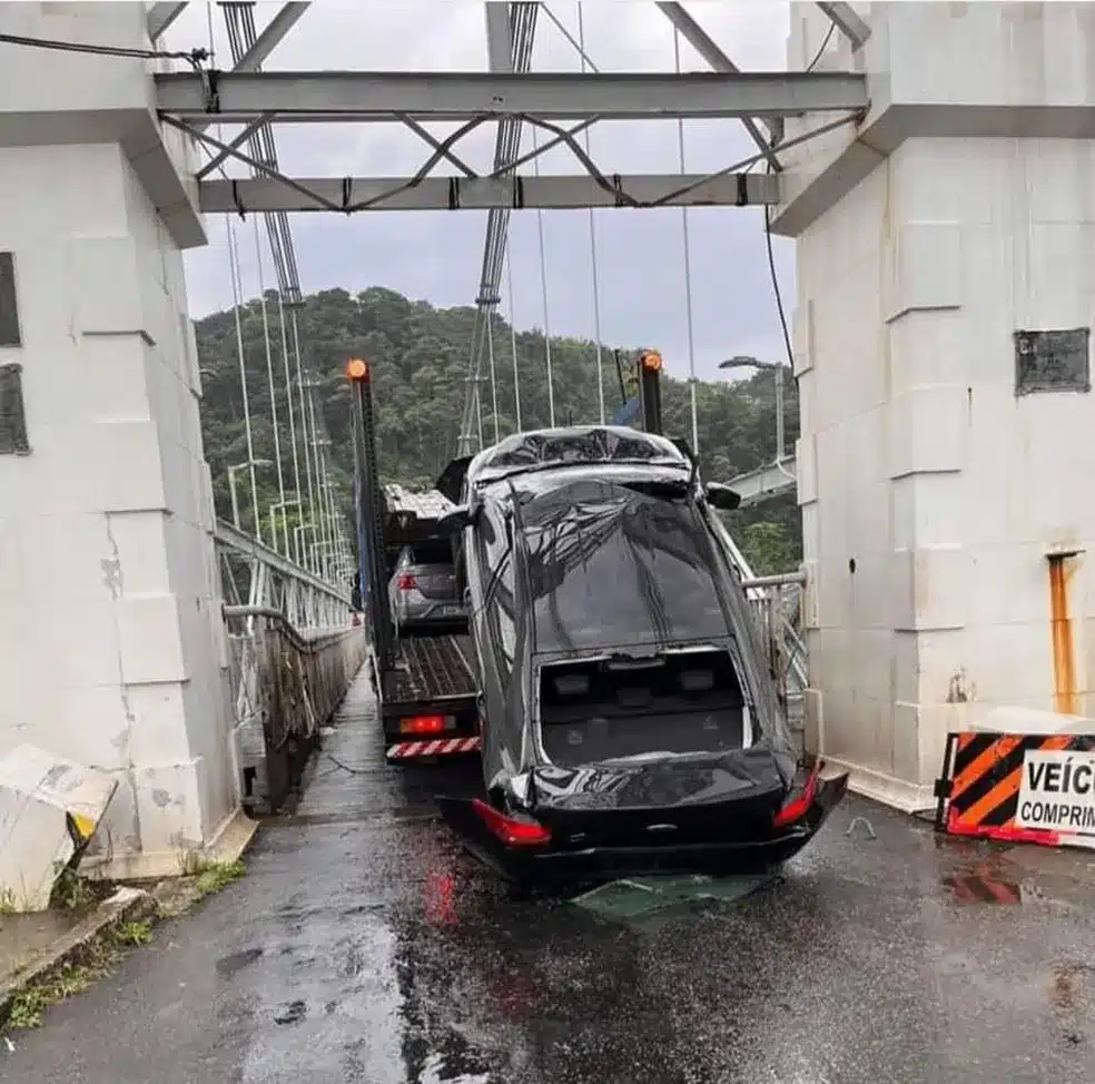 Caminhão cegonha entala em ponte e veículo transportado é danificado, em São Vicente