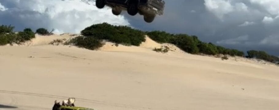 Picape voa sobre buggy com passageiros em duna no Ceará